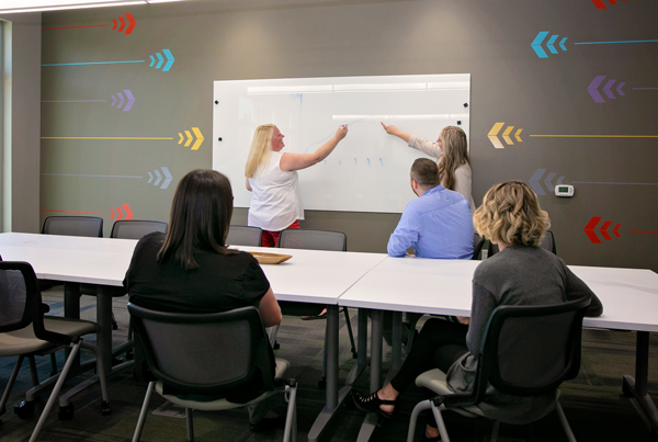 Vesta team in conference room writing on board.